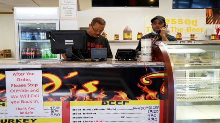 Red Harris, left, the owner of Reds The One And Only BBQ, at the restaurant in Ferguson, Mo., June 2, 2020. As demonstrations protesting racism and police violence continued in the city, a dozen employees of a non-bank community lending organization called Justine Petersen stood vigil outside Harris’s business to protect it from looting and damage. (Vanessa Charlot/The New York Times)
