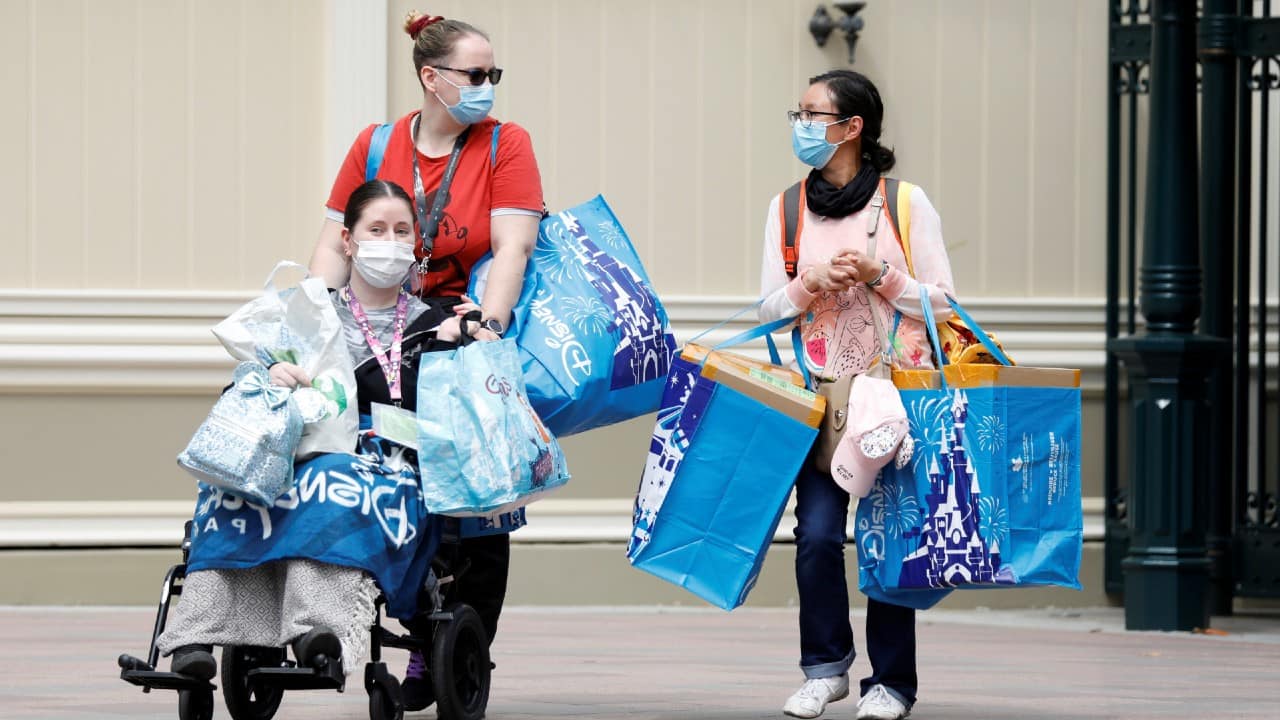 Visitors leaves Disneyland Paris with bags full of souvenirs as the theme park reopens its doors to the public in Marne-la-Vallee on July 15. (Image: Reuters)