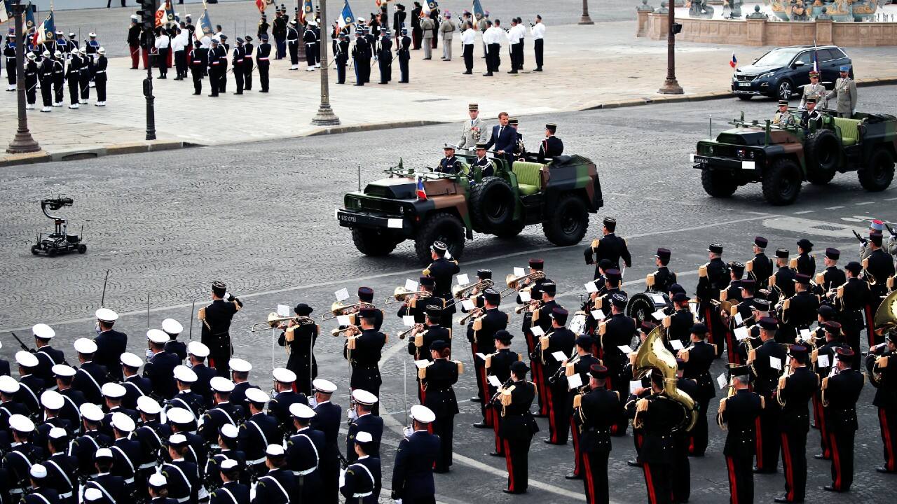 France's President Emmanuel Macron and French Armies Chief Staff General Francois Lecointre, centre left, stand in the command car as they review troops before the start of the Bastille Day military parade. (Image: AP)
