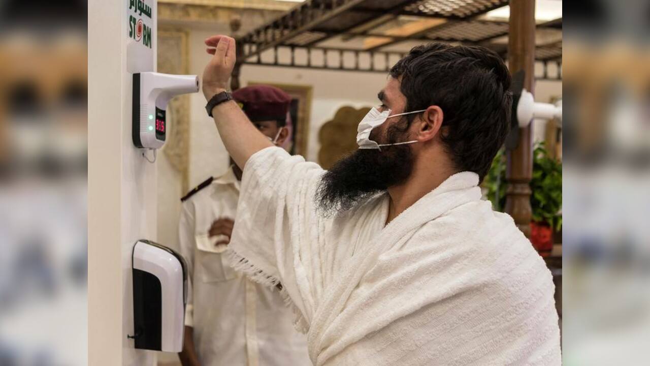 A Muslim pilgrim wearing a protective face mask has his temperature checked as he arrives in Mina, July 29. (Image: Saudi Press Agency via REUTERS)