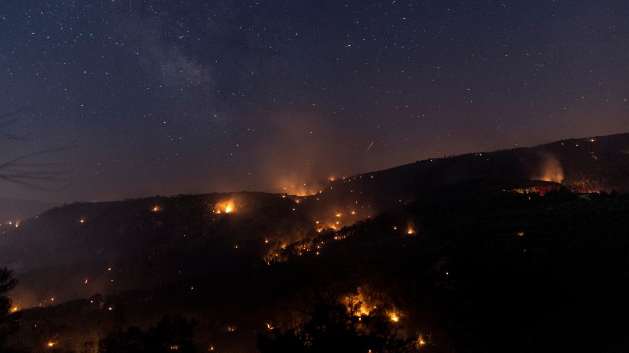 Greek firefighters battled a wind-driven forest fire that burned through pine forest and forced the evacuation of hundreds of people near the seaside village of Kechries in the eastern Peleponnese. Thick dark smoke clouded the area. More than 250 firefighters were struggling on July 23 to contain a large wildfire fanned by strong winds that raged through forests. A drop in high winds late July 24 helped firefighters gain ground on a large wildfire. Firefighters and water-dropping aircraft were fighting to contain a large wildfire in southern Greece that forced evacuations and a night-long battle to save homes. (Image: AP) Greek firefighters battled a wind-driven forest fire that burned through pine forest and forced the evacuation of hundreds of people near the seaside village of Kechries in the eastern Peleponnese. Thick dark smoke clouded the area. More than 250 firefighters were struggling on July 23 to contain a large wildfire fanned by strong winds that raged through forests. A drop in high winds late July 24 helped firefighters gain ground on a large wildfire. Firefighters and water-dropping aircraft were fighting to contain a large wildfire in southern Greece that forced evacuations and a night-long battle to save homes. (Image: AP)