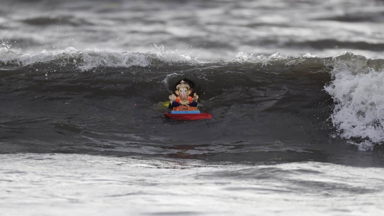 A devotee immerses an idol of Hindu god Ganesha on the fifth day of the ten-day long Ganesh Chaturthi festival in the Arabian sea in Mumbai, India, Wednesday, Aug. 26, 2020. The festival is a celebration of the birth of Ganesha, the Hindu god of wisdom, prosperity and good fortune. (Image: AP Photo/Rajanish Kakade)