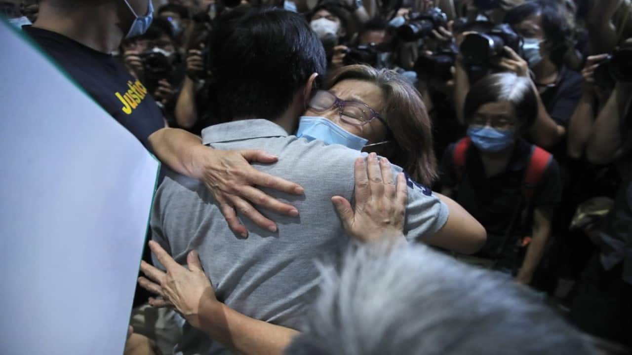 Pro-democracy legislator Ted Hui, hugs a supporter after being released on bail outside a court in Hong Kong, Thursday, Aug. 27, 2020. Hong Kong police arrested 16 people, including two opposition lawmakers, on Wednesday on charges related to anti-government protests last year. (Image: AP Photo/Kin Cheung)