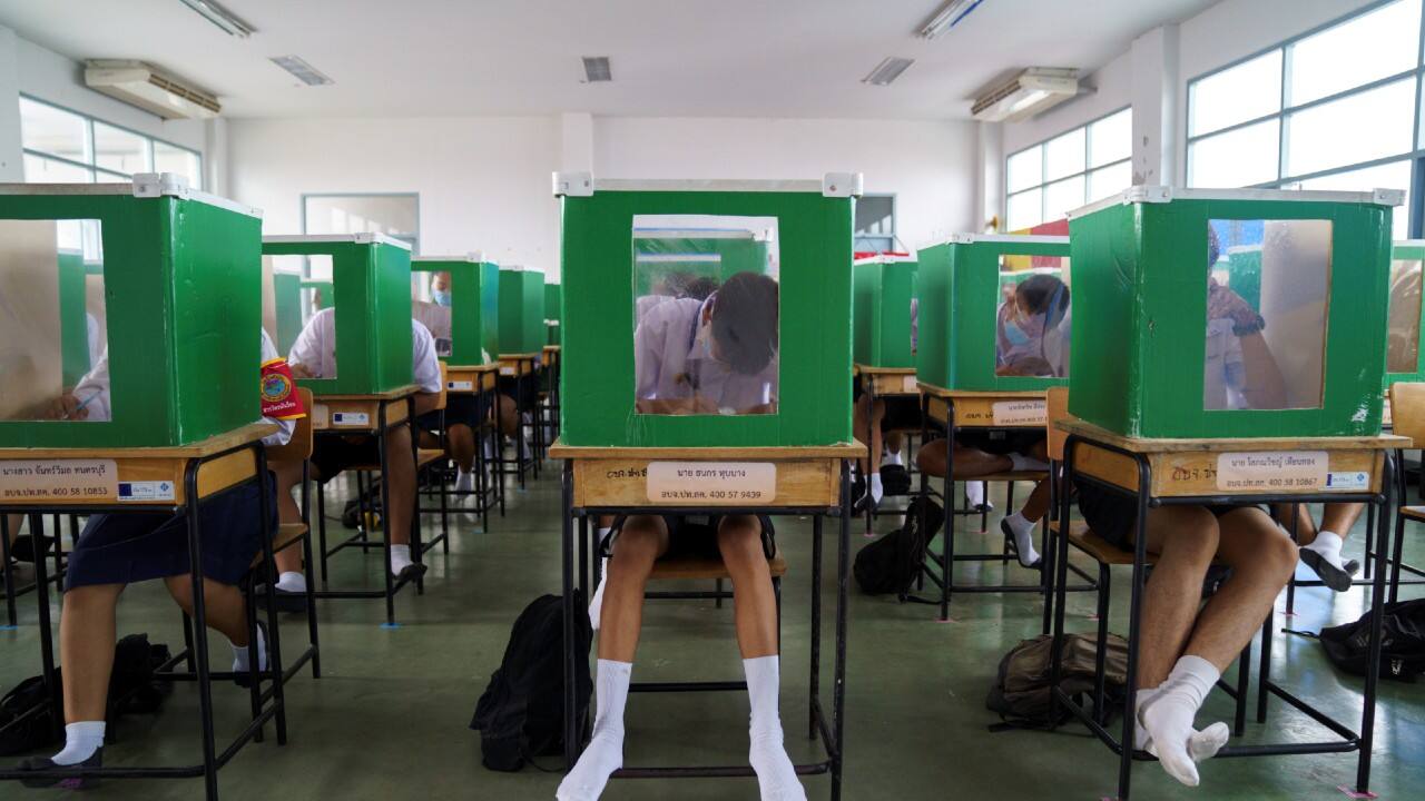 Students of Sam Khok school wearing face masks and face shields are seen inside old ballot boxes repurposed into partitions as they attend a class after the Thai government eased isolation measures and introduced social distancing to prevent the spread of the coronavirus as schools nationwide reopen, at Pathum Thani province, Thailand, July 1. (Image: Reuters)