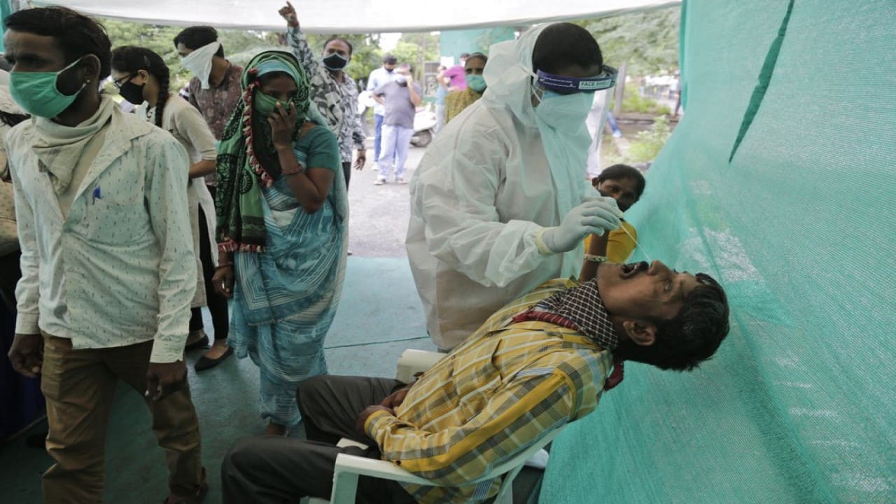 A health worker takes a nasal swab sample to test for COVID-19 at a check post erected to screen people coming from outside the city, in Ahmedabad, India, Tuesday, Aug. 25, 2020. India has the third-highest coronavirus caseload after the United States and Brazil, and the fourth-highest death toll in the world. (Image: AP Photo/Ajit Solanki)