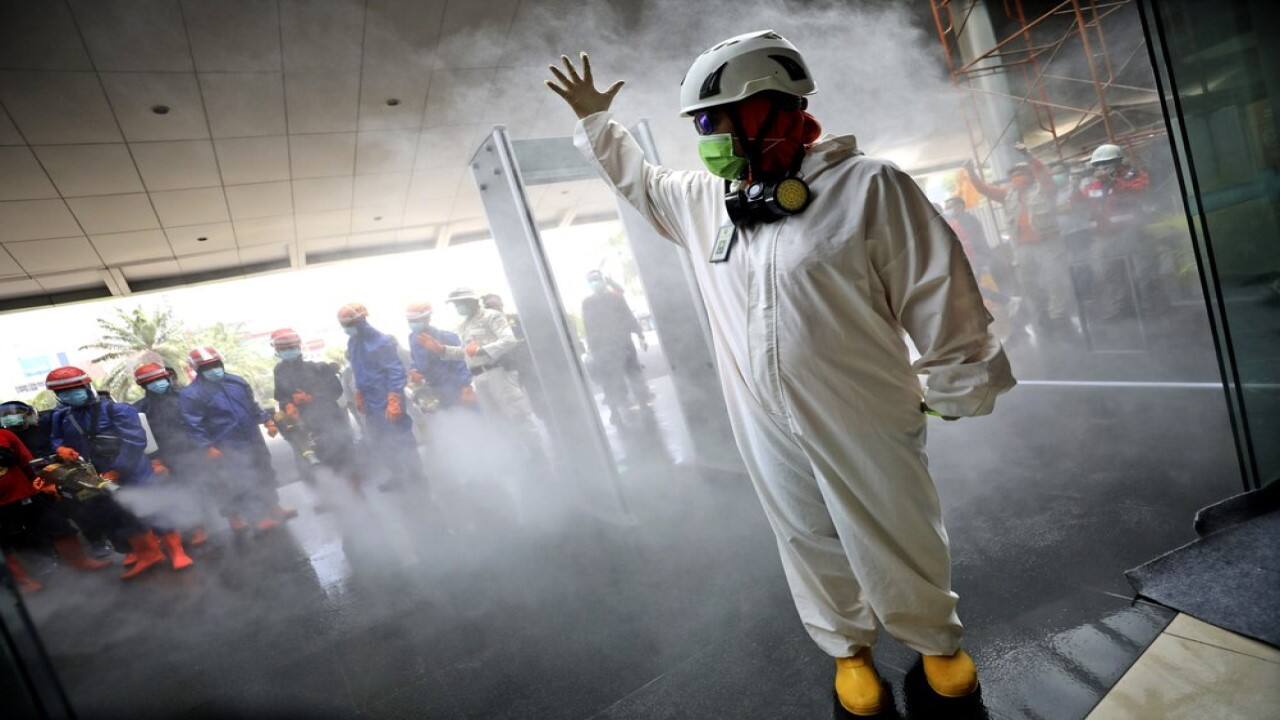 A team leader makes a hand signal as Indonesian firemen test their equipment prior to disinfecting Margo City shopping mall to help curb the spread of the new coronavirus outbreak, after a number of employees of a supermarket at the mall were tested positive for the virus, in Depok, Indonesia, Saturday, Aug. 22, 2020. (Image: AP Photo/Dita Alangkara)