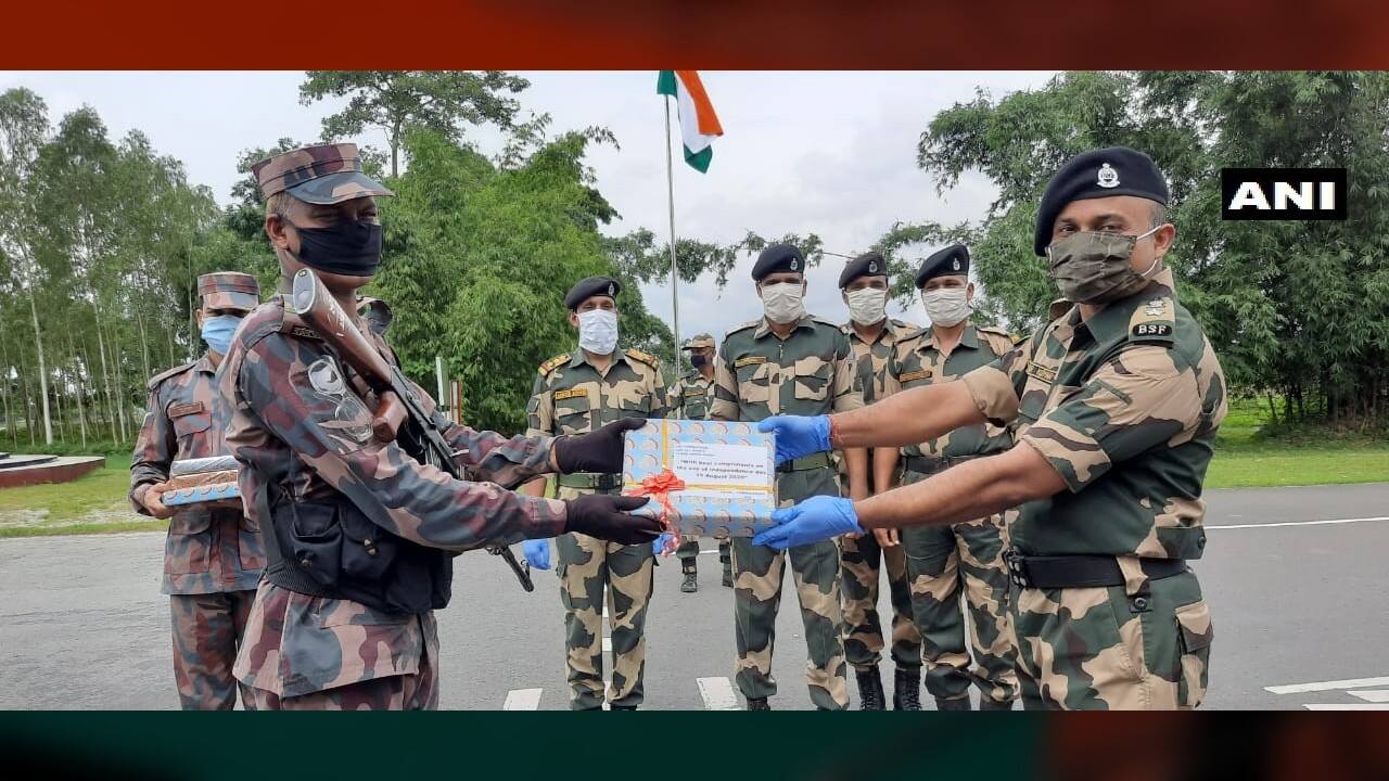 Border Security Force (BSF) and Border Guard Bangladesh (BGB) exchange sweets at India-Bangladesh border in Phulbari, West Bengal. (Image: Twitter @ANI)