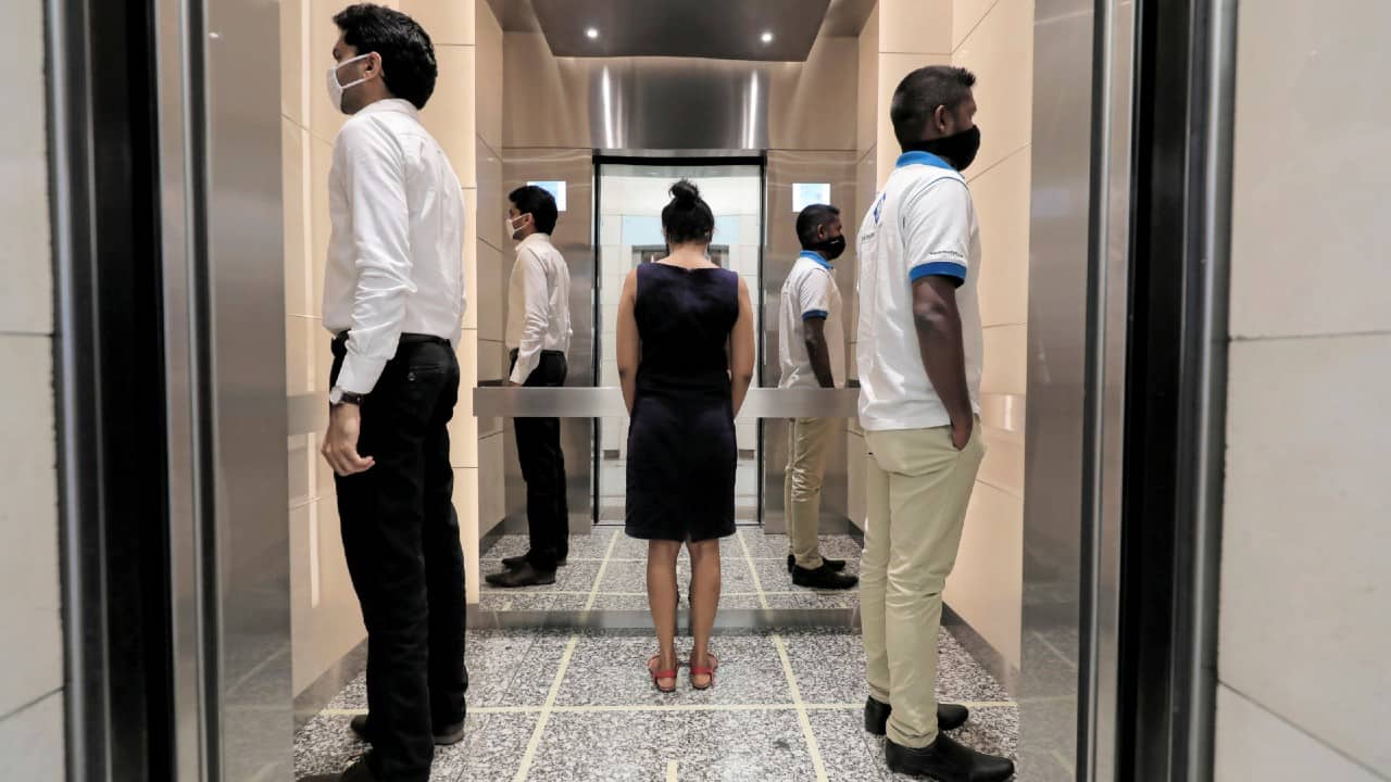People practice social distancing inside an elevator prior to arriving to their work places at World Trade Center, after the government announced that private and state companies will reopen their offices after almost two months of lockdown amidst concerns about the spread of coronavirus in Colombo, Sri Lanka May 11. (Image: Reuters)