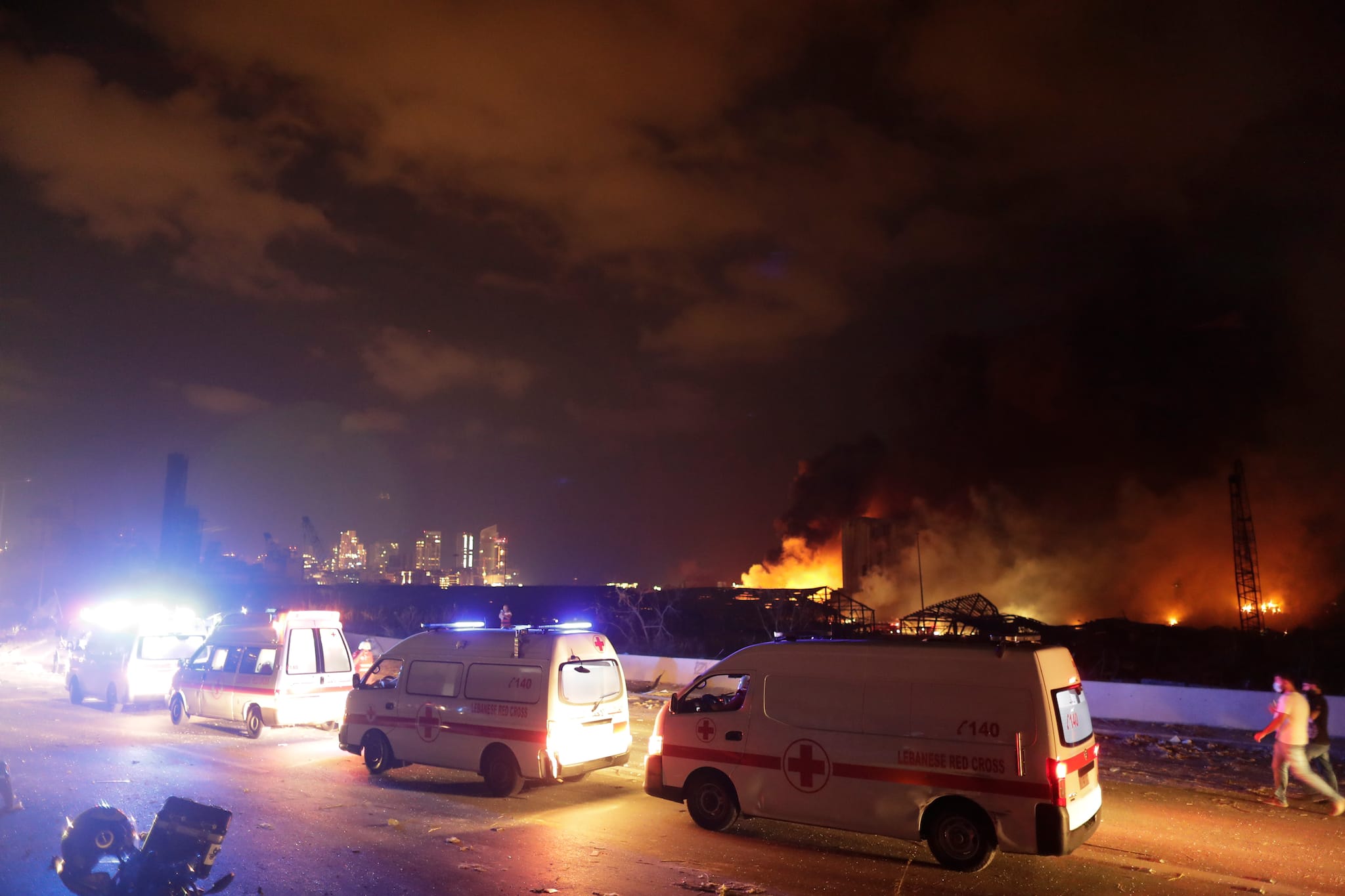Ambulances drive past the site of a massive explosion in Beirut, Lebanon, Tuesday, Aug. 4, 2020. (AP Photo/Hassan Ammar)