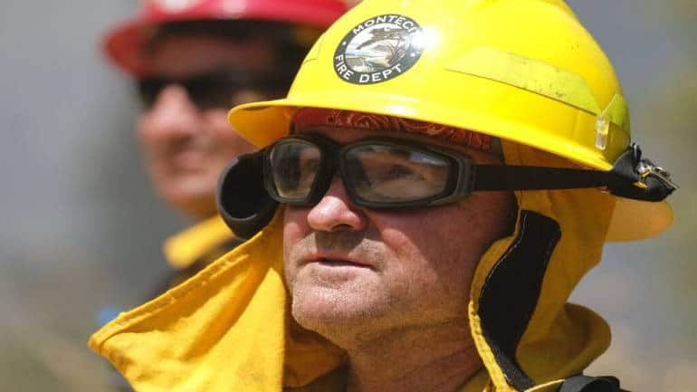 A firefighter watches the Apple Fire in Banning, California. Flames leapt along brushy ridge tops and came close to homes while firefighters attacked it from the ground and air. (Image courtesy: AP)