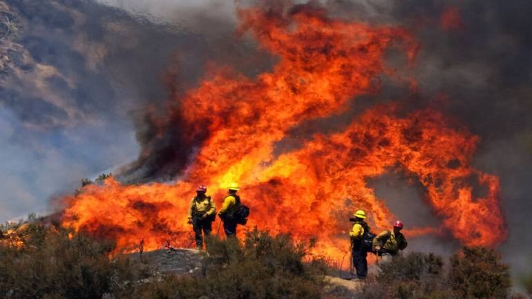 Firefighter watches the Apple Fire in Banning, California. The mercury hit 109 degrees (43 Celsius) Sunday in nearby Palm Springs. (Image courtesy: AP)