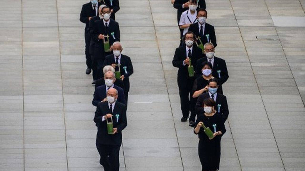 Participants, many of them dressed in black and wearing face masks, offered a silent prayer at exactly 8:15 am (2315 GMT Wednesday), the time the first nuclear weapon used in wartime was dropped over the city.