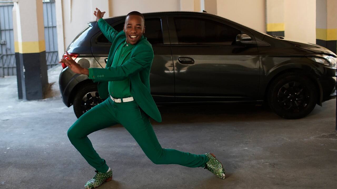 Jesus strikes a pose for reporters next to his car in Rio de Janeiro