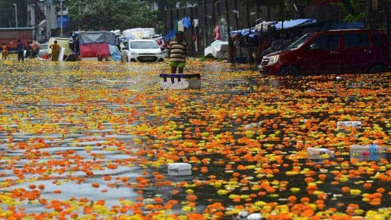 A vendor stands in a flooded flower market following heavy monsoon rains (Image: AFP)
