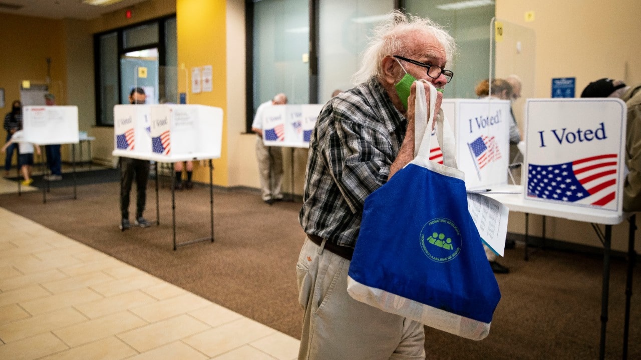 A man walks to place his ballot into a machine at an early voting site in Arlington, Virginia. (Image: Reuters)