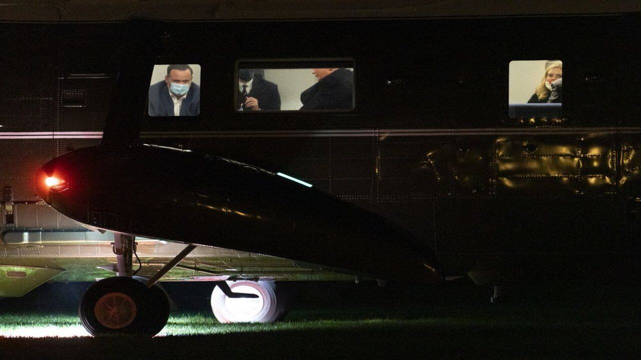 President Donald Trump, center, is seen seated inside Marine One helicopter, not wearing a face mask, as he and members of his staff, including White House director of social media Dan Scavino, left, arrive at the White House in Washington, October 1, 2020. (AP Photo)