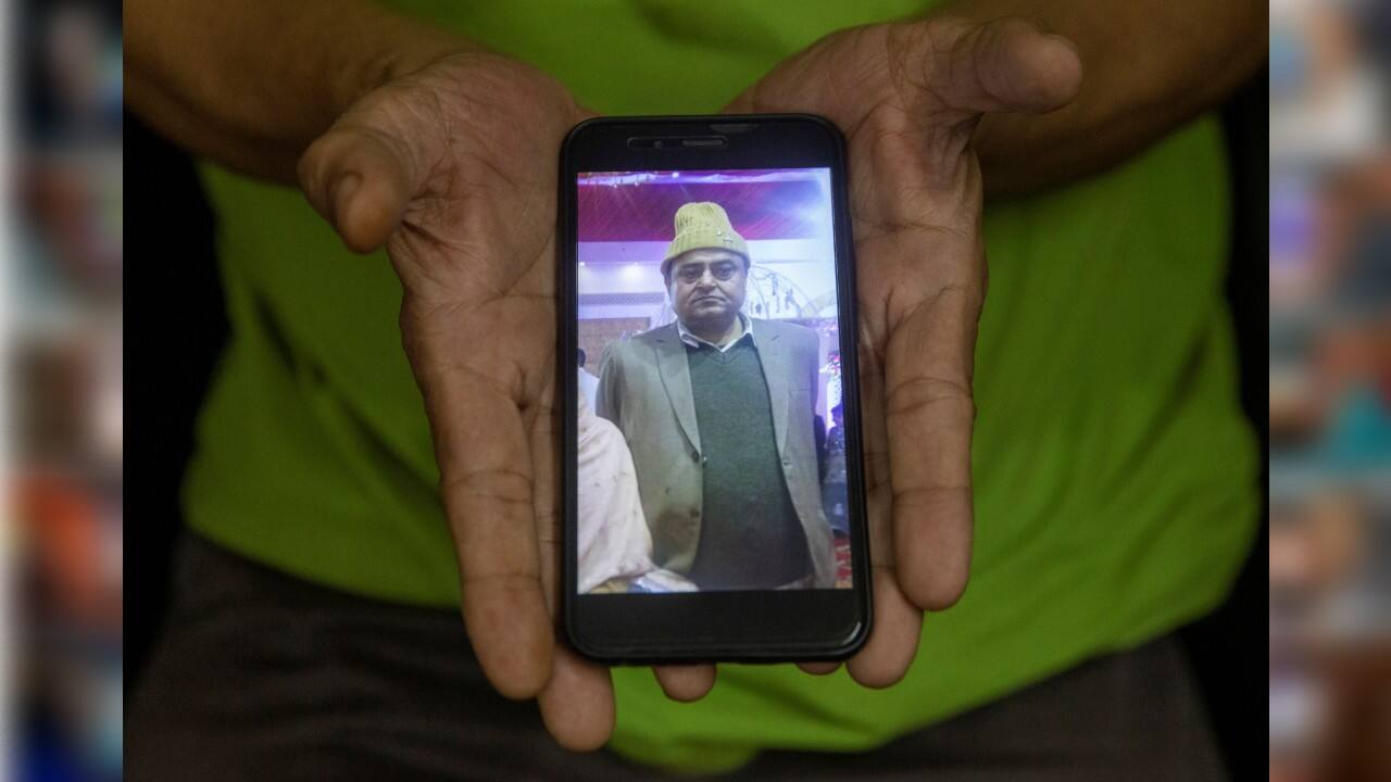 Mohd Rehan, holds a phone with the photograph of his brother Mohd. Fareed, 62, a businessman, who died due to the coronavirus disease, in New Delhi, India, September 24. "He had no symptoms and was laughing when the first test results came. He thought there was some mistake. His health suddenly deteriorated next day and he died a day after. It was unbelievable. He was a very jolly person" said his brother Mohd Rehan, a businessman. (Image: Reuters) Mohd Rehan, holds a phone with the photograph of his brother Mohd. Fareed, 62, a businessman, who died due to the coronavirus disease, in New Delhi, India, September 24. "He had no symptoms and was laughing when the first test results came. He thought there was some mistake. His health suddenly deteriorated next day and he died a day after. It was unbelievable. He was a very jolly person" said his brother Mohd Rehan, a businessman. (Image: Reuters)