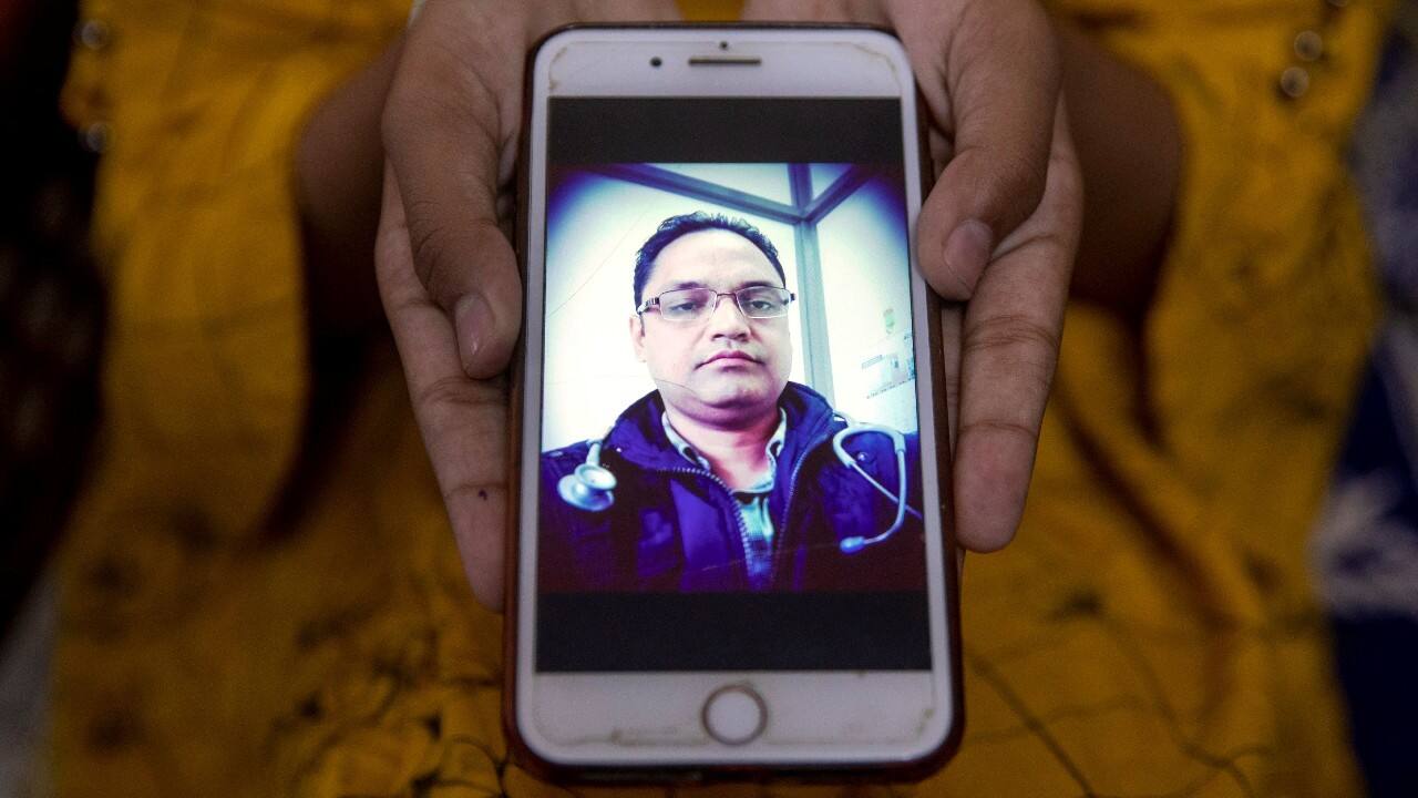 Aliza Ali, 12, shows a picture on her phone of her father Javed Ali, a government doctor, who died due to the COVID-19, as she poses for a photograph, in New Delhi, India, September 23. "He was taking all the precautions while continuously working on the frontline without any breaks until he got symptoms. I am proud of him; my children are proud of him. But we are having an extremely difficult time to cope with the present situation. Not a single day goes by when we don't remember Javed and cry," said Javed Ali's wife, Hena Kausar, a doctor. (Image: Reuters) Aliza Ali, 12, shows a picture on her phone of her father Javed Ali, a government doctor, who died due to the COVID-19, as she poses for a photograph, in New Delhi, India, September 23. "He was taking all the precautions while continuously working on the frontline without any breaks until he got symptoms. I am proud of him; my children are proud of him. But we are having an extremely difficult time to cope with the present situation. Not a single day goes by when we don't remember Javed and cry," said Javed Ali's wife, Hena Kausar, a doctor. (Image: Reuters)