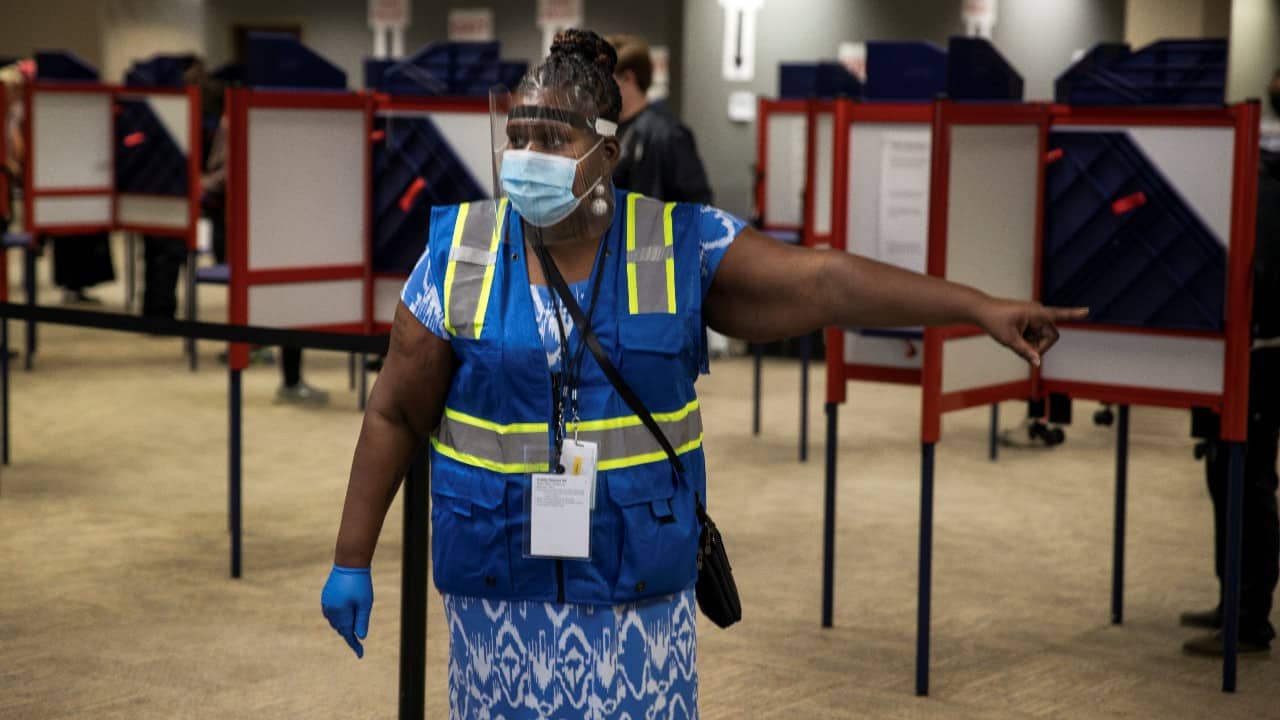 A poll worker directs voters to cast their ballots for the upcoming presidential election as early voting begins in Cincinnati, Ohio. (Image: Reuters)