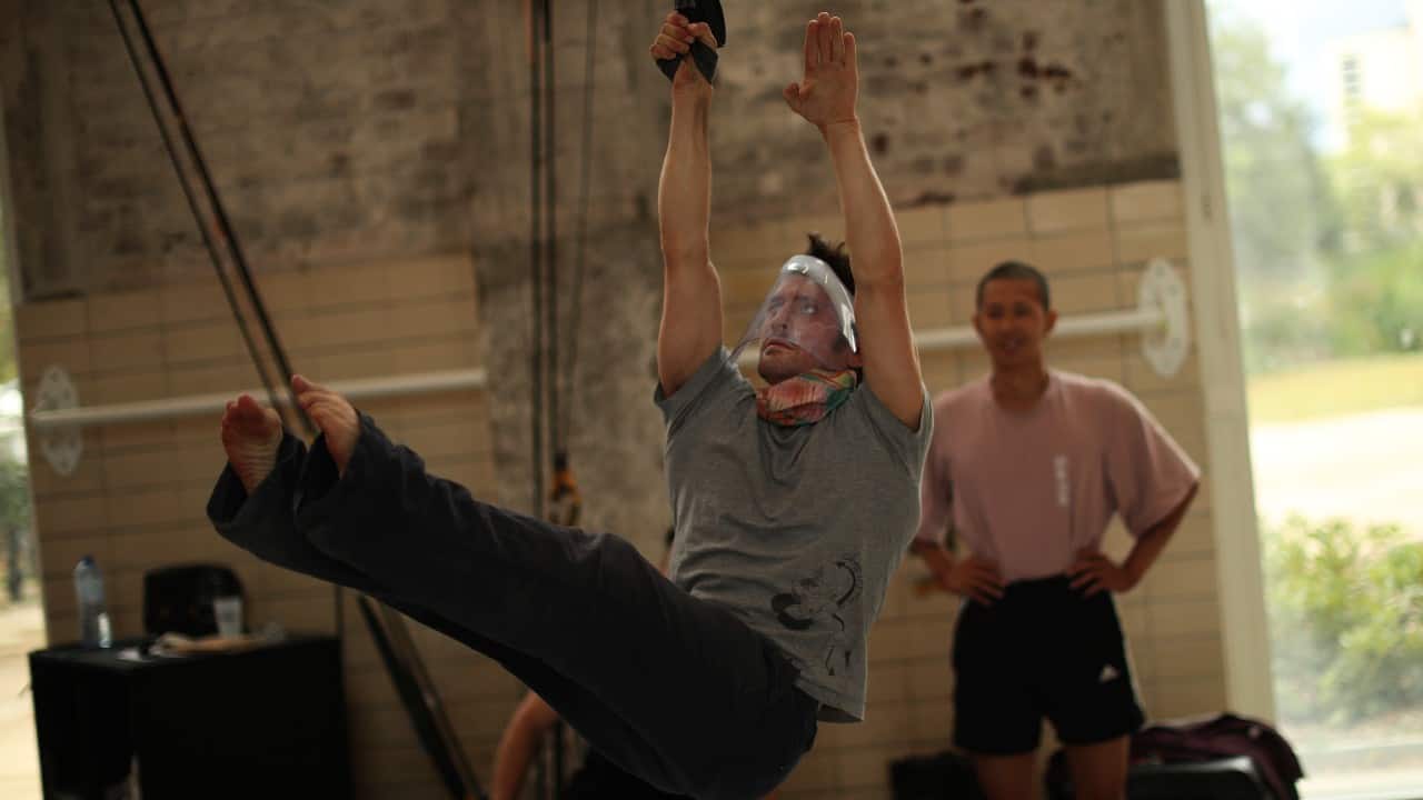 The pandemic forced the school to close in March, but with new measures in place to limit exposure the smell of sweat and the grunts of exertion are back again. A teacher, wearing a face shield to fight against the spread of coronavirus, shows students how to improve their technique during a class at the Superior School of Circus Arts (ESAC) in Brussels, September 24, 2020. (Image: AP)