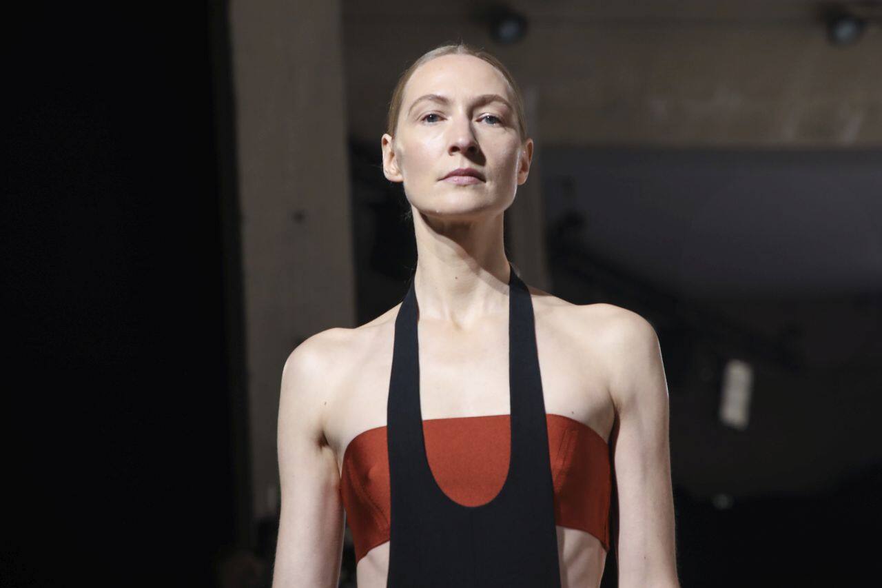 VIVIENNE WESTWOOD | Andreas Kronthaler got saucy dressing up his partner, fashion icon Vivienne Westwood, in bright red fishnet stockings and champagne pink satin stilettos as she did a turn as a model. Hair sprayed back in a bouffant and wearing a loose red check dress and a large black-gold chain, the 79-year-old Westwood looked free, glamorous and empowered. (Source: AP News)