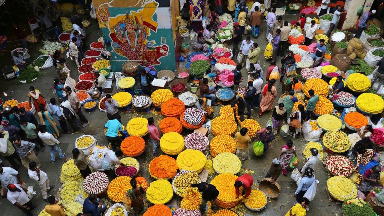 People shop for flowers ahead of Dusshera. In view of the threat of COVID-19 infection, difficulties in keeping the crowd size under 200 and enforcing social distancing, many Dussehra festival organisers have resorted to using footage of previous years as well as audio-visual and light effects to recreate effigy burning and stream it online. (Image: AP) People shop for flowers ahead of Dusshera. In view of the threat of COVID-19 infection, difficulties in keeping the crowd size under 200 and enforcing social distancing, many Dussehra festival organisers have resorted to using footage of previous years as well as audio-visual and light effects to recreate effigy burning and stream it online. (Image: AP)