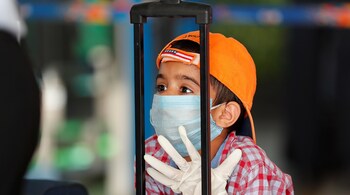 A child wearing a protection mask and gloves is seen at Indira Gandhi International (IGI) airport. (Image: Reuters)