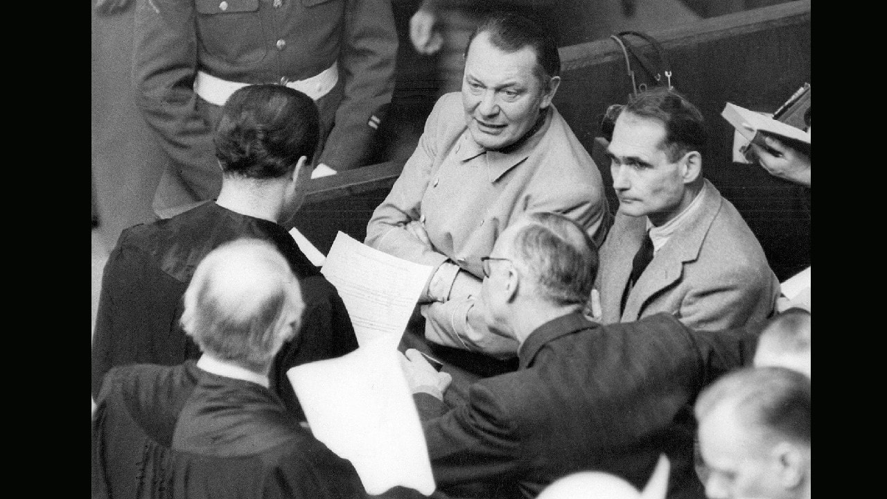 Rudolf Hess, right, has asked permission of the international military tribunal to be allowed to act as his own attorney “from now until the end of the trial.” He is discussing his application during a recess in the Nuremberg trial, with Goering, Ribbentrop and two lawyers on January 28, 1946. Goering appears to be taking a keen interest in the proceedings. (Image: AP) Rudolf Hess, right, has asked permission of the international military tribunal to be allowed to act as his own attorney “from now until the end of the trial.” He is discussing his application during a recess in the Nuremberg trial, with Goering, Ribbentrop and two lawyers on January 28, 1946. Goering appears to be taking a keen interest in the proceedings. (Image: AP)