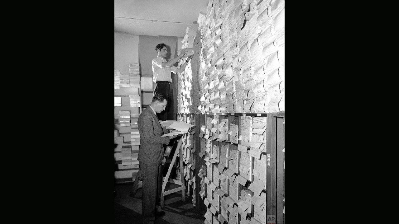 Director of the document section of the Nuremberg Trials, Fred Niebergall, receives a stack of papers from a German file clerk in one of the many rooms full of documents, in the Nuremberg Palace of Justice Building, Germany on June 16, 1948. Mr. Niebergall has been in charge of the trial documents since August 1945 before the trials started. Sixty-thousand documents are on file. (Image: AP) Director of the document section of the Nuremberg Trials, Fred Niebergall, receives a stack of papers from a German file clerk in one of the many rooms full of documents, in the Nuremberg Palace of Justice Building, Germany on June 16, 1948. Mr. Niebergall has been in charge of the trial documents since August 1945 before the trials started. Sixty-thousand documents are on file. (Image: AP)