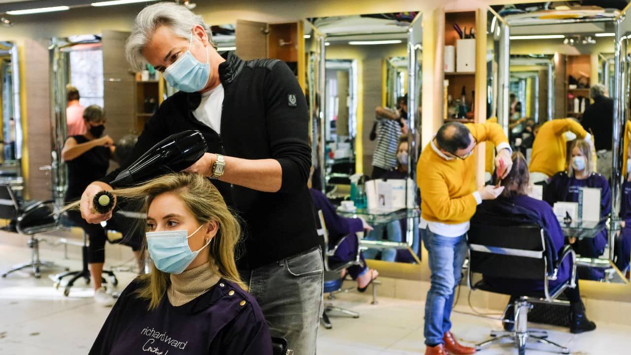 With time running out to get things sorted before the lockdown takes effect, many shops and hair salons extended their hours and reported brisk customer traffic on the last day. Richard Ward, owner of Richard Ward Hair &amp; MetroSpa wears a protective face mask as he works in his salon in London, November 4. (Image: AP)