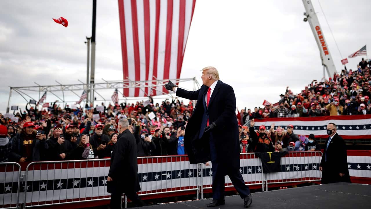 U.S. President Donald Trump tosses out a cap as he holds a campaign rally at Reading Regional Airport in Reading Pennsylvania, U.S., October 31. (Image: Reuters)