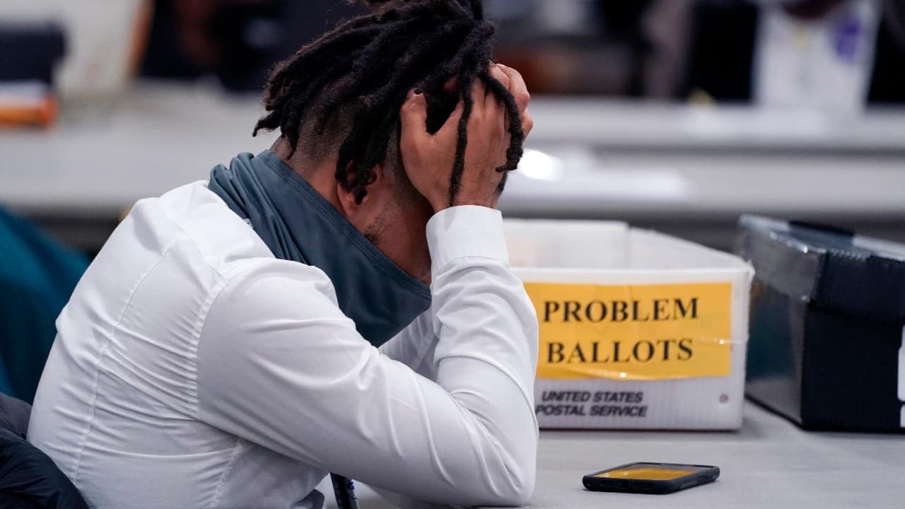 An election worker rubs his head in the closing hours where absentee ballots were processed at the central counting board in Detroit. (Image: AP/Carlos Osorio)