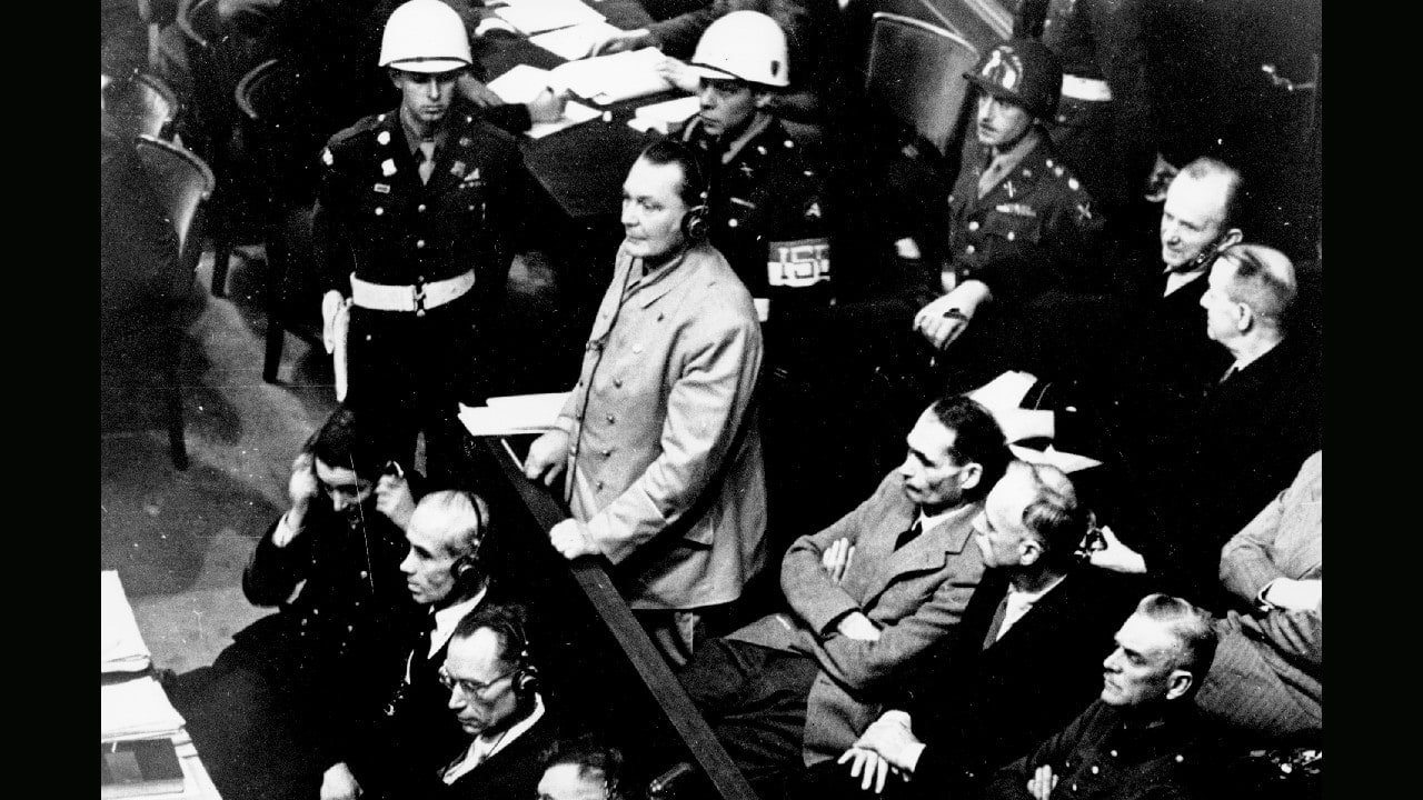 Reichsmarshal Hermann Goering stands in the prisoner's dock at the Nuremberg War Crimes Trial in Germany on November 21, 1945. He is entering a plea of not guilty to the International Military Tribunal Indictment. Goering is wearing headphones of the court translating system. (Image: AP) Reichsmarshal Hermann Goering stands in the prisoner's dock at the Nuremberg War Crimes Trial in Germany on November 21, 1945. He is entering a plea of not guilty to the International Military Tribunal Indictment. Goering is wearing headphones of the court translating system. (Image: AP)