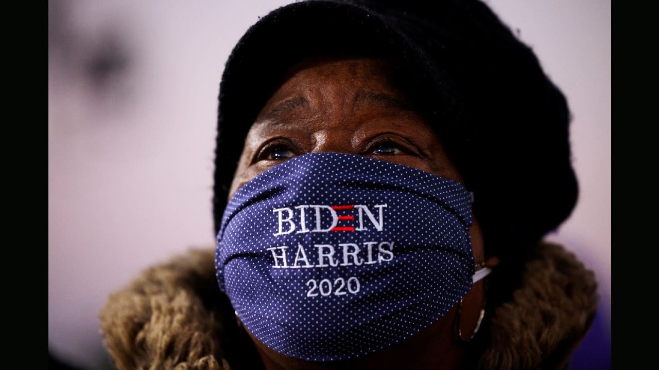 An attendee wearing a "Biden Harris 2020" face mask watches Democratic U.S. presidential nominee and former Vice President Joe Biden at a campaign drive-in, mobilization event in Detroit, Michigan, U.S., October 31. (Image: Reuters)