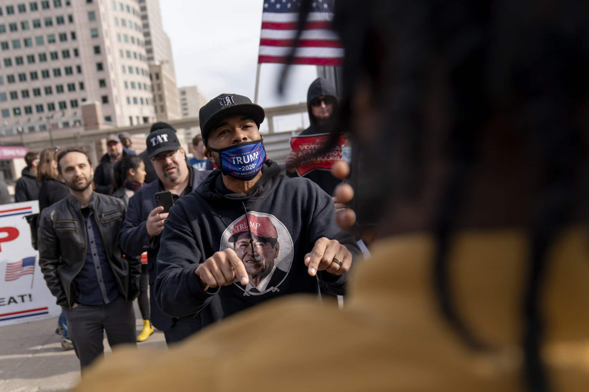 Trump supporter Charles Littleton, center, argues with Biden supporter Angelo Austin, right, as Trump supporters protest election results outside the central counting board at the tcf Center in Detroit, Mich., Thursday, Nov. 5, 2020. (AP Photo/David Goldman)