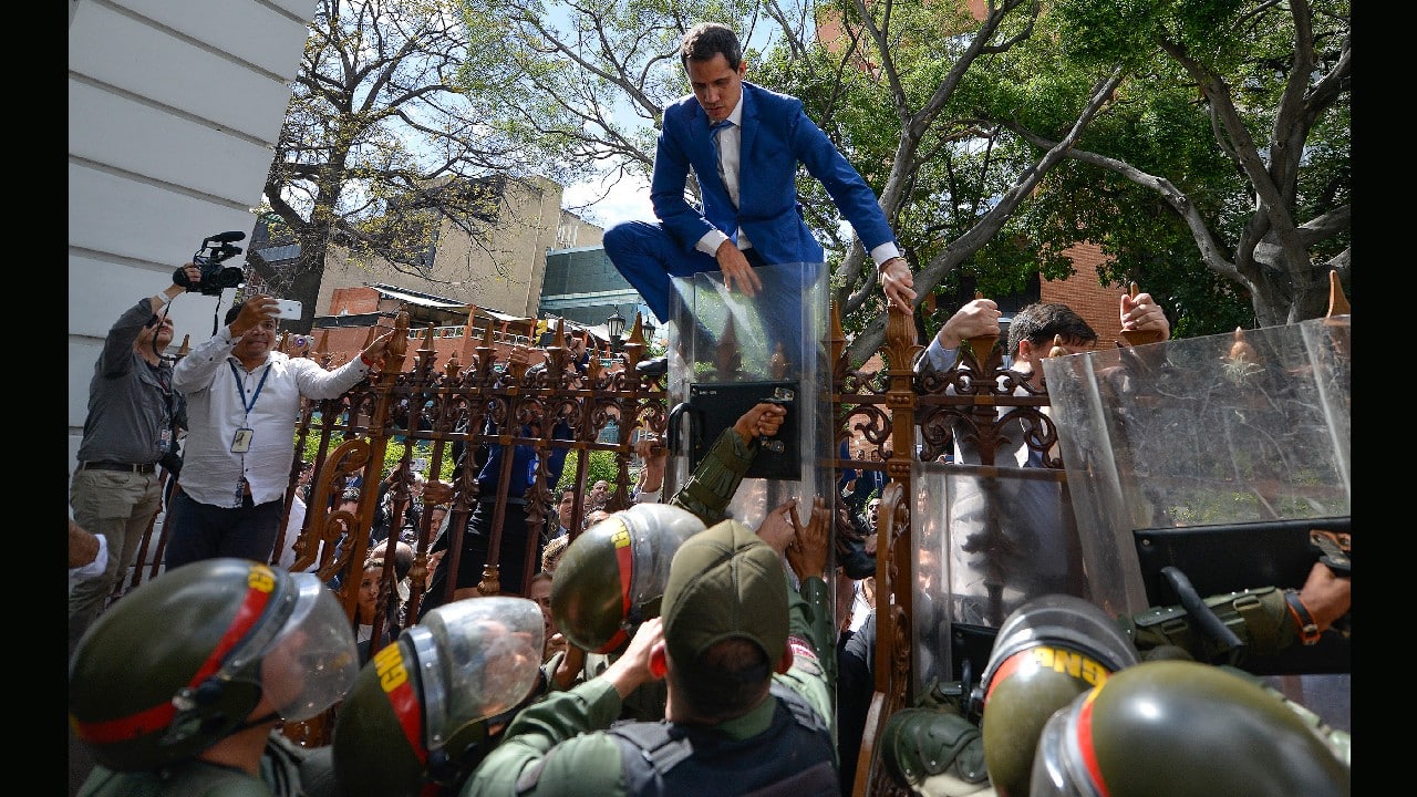 National Assembly President Juan Guaido, Venezuela's opposition leader, climbs the fence in a failed attempt to enter the Assembly compound as he and other opposition lawmakers are blocked from entering a session to elect the body's new leadership in Caracas, Venezuela, January 5. (Image: AP)