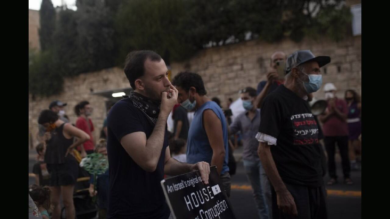 In Israel, protesters held the largest anti-government demonstrations in years, demanding that Prime Minister Benjamin Netanyahu resign over his trial on corruption charges and his government's handling of the pandemic. In one photo, a protester can be seen kneeling in the street with an Israeli flag, drenched by a police water cannon. (Image: AP)
