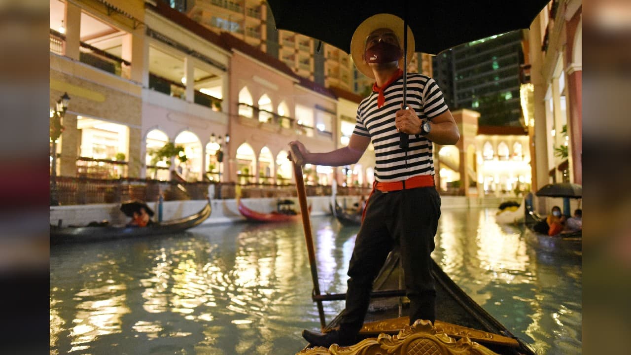 Gondoliers in striped uniforms steer and position each boat in an outdoor canal to watch full-length films, a rare chance to visit the cinema after nine months of lockdowns. (Image: Reuters) Gondoliers in striped uniforms steer and position each boat in an outdoor canal to watch full-length films, a rare chance to visit the cinema after nine months of lockdowns. (Image: Reuters)