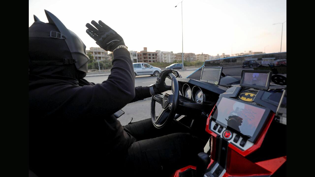 Bassem Raaof, 28, dressed in a Batman costume, waves as he drives his &quot;Batmobile&quot; replica around his neighbourhood handing out face masks to residents during Christmas season, amid the COVID-19 pandemic in Cairo, Egypt. (Image: Reuters)