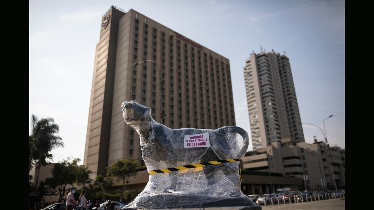 A sculpture of a lioness outside the Palace of Justice is wrapped in plastic in Lima, Peru, November 21. Some other monuments were simply surrounded by police officers during the protests to avoid any damage. (Image: AP)