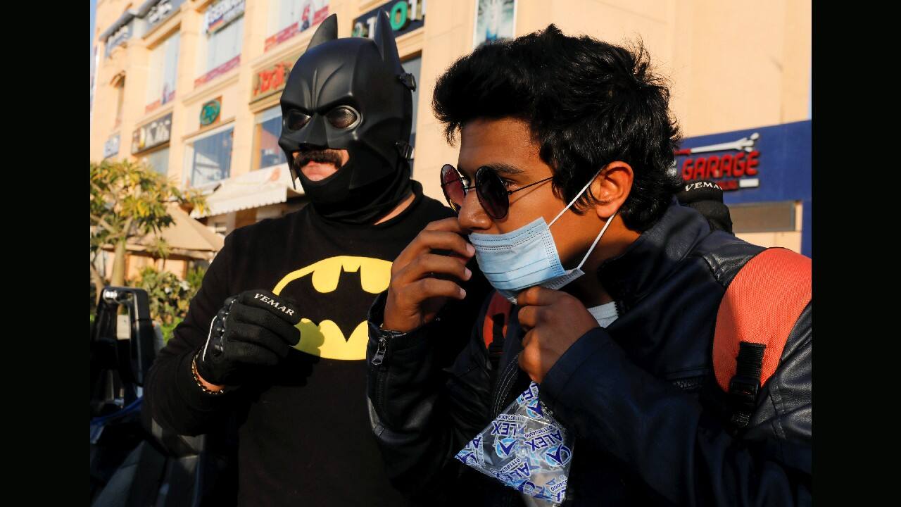 A man wears a face mask supplied by Bassem Raaof dressed in a Batman costume, who is handing out face masks to residents of his neighborhood during Christmas season, amid the coronavirus pandemic in Cairo, Egypt December 17. (Image: Reuters)