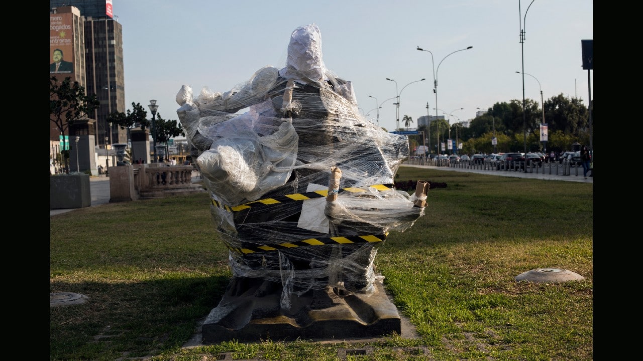 A bronze statue of an Andean farmer with two bulls plowing the land, is wrapped in plastic, located on the Paseo de los Heroes Boulevard in Lima, Peru, November 21. Target of attacks in other countries during social and political protests, historical monuments and statues in Peru's capital came out of recent street demonstrations practically intact. (Image: AP)