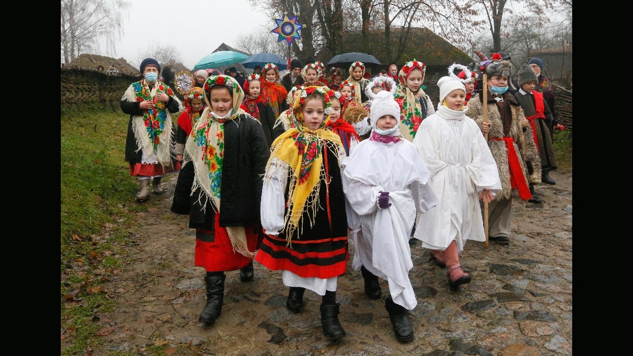 Children dressed in Ukrainian folk costumes carry a symbol of the Bethlehem Star singing Christmas carols as they traditionally visit neighbors to mark Orthodox Christmas in the village of Pirogovo outside the capital Kyiv, Ukraine, January 7. (Image: AP/Efrem Lukatsky)