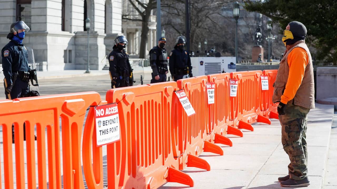 A supporter of U.S. President Donald Trump stands in front of Pennsylvania State Capitol guarded by Pennsylvania State Capitol Police, as he protests against the election of President-elect Joe Biden, in Harrisburg, Pennsylvania, U.S. January 17. (Image: Reuters) A supporter of U.S. President Donald Trump stands in front of Pennsylvania State Capitol guarded by Pennsylvania State Capitol Police, as he protests against the election of President-elect Joe Biden, in Harrisburg, Pennsylvania, U.S. January 17. (Image: Reuters)