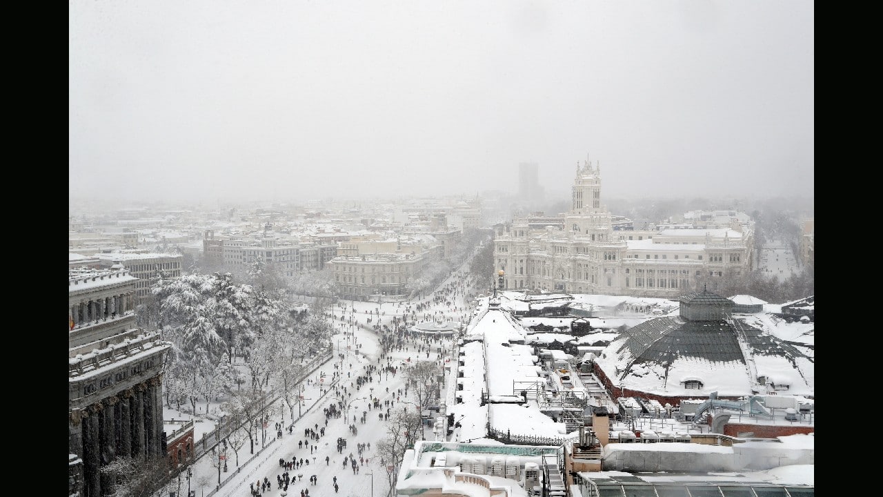 People are seen from the rooftop of the Circulo de Bellas Artes cultural center, as they stand and walk near the Cibeles Fountain and the City Hall building during a heavy snowfall in Madrid, Spain January 9. (Image: Reuters)