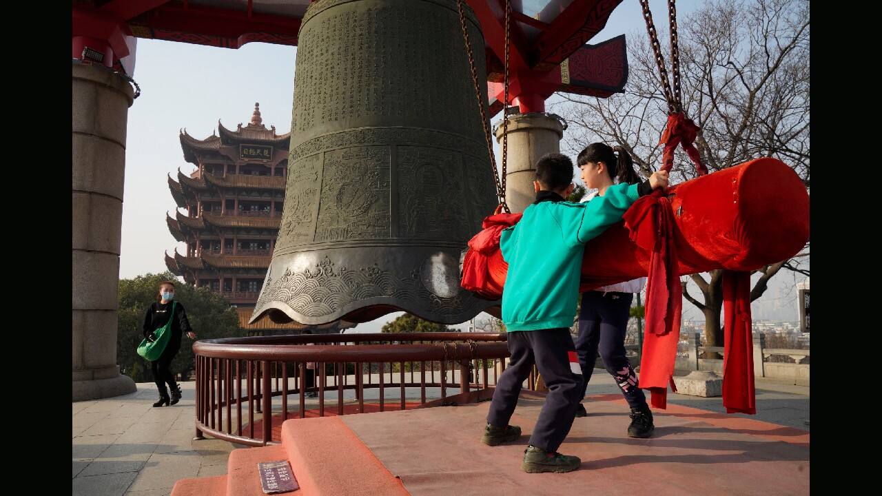 Children rings a bell as they visit the iconic Yellow Crane Tower, a popular tourist site in Wuhan in central China's Hubei province on January 15. (Image: AP)