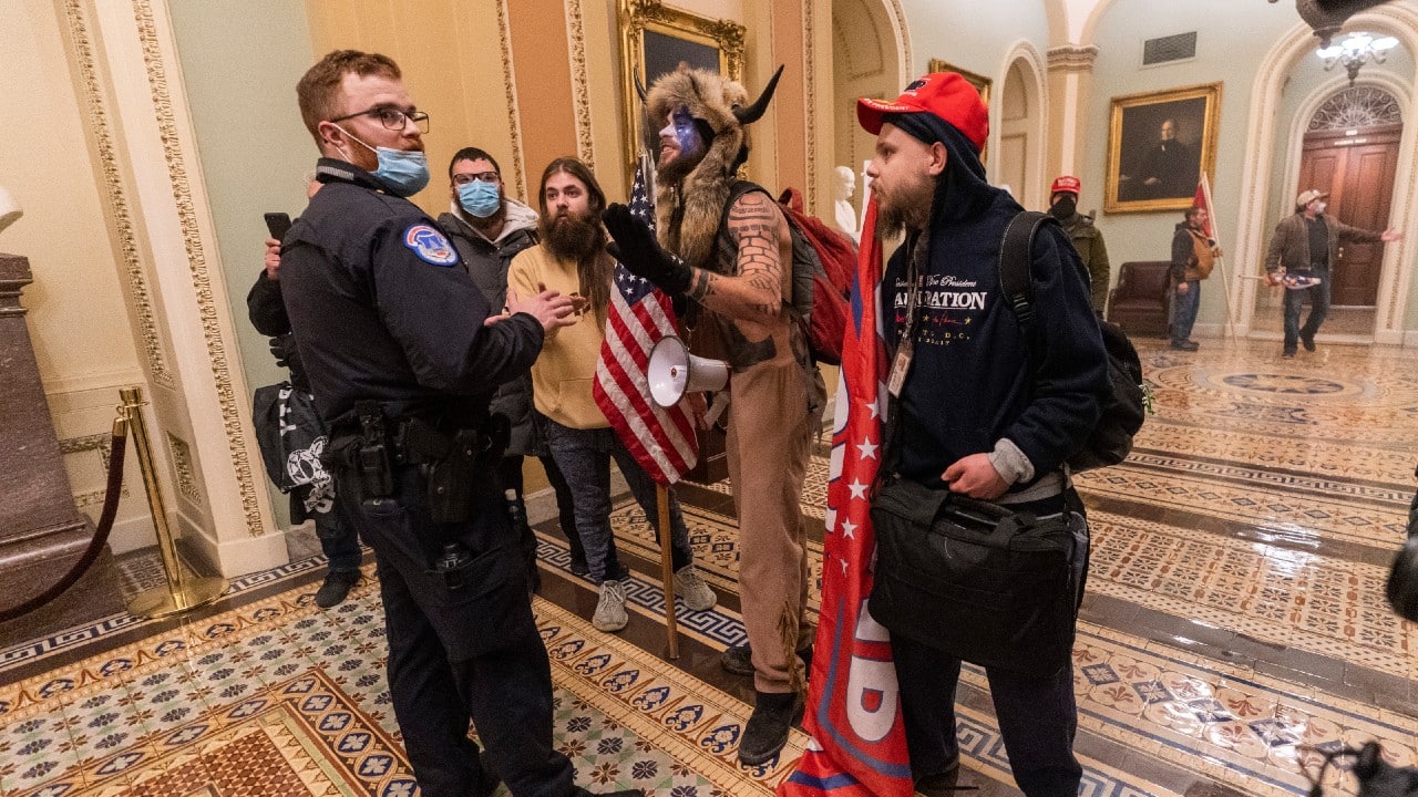 Supporters of US President Donald Trump are confronted by Capitol Police officers outside the Senate Chamber inside the Capitol building. (Image: AP Photo/Manuel Balce Ceneta)