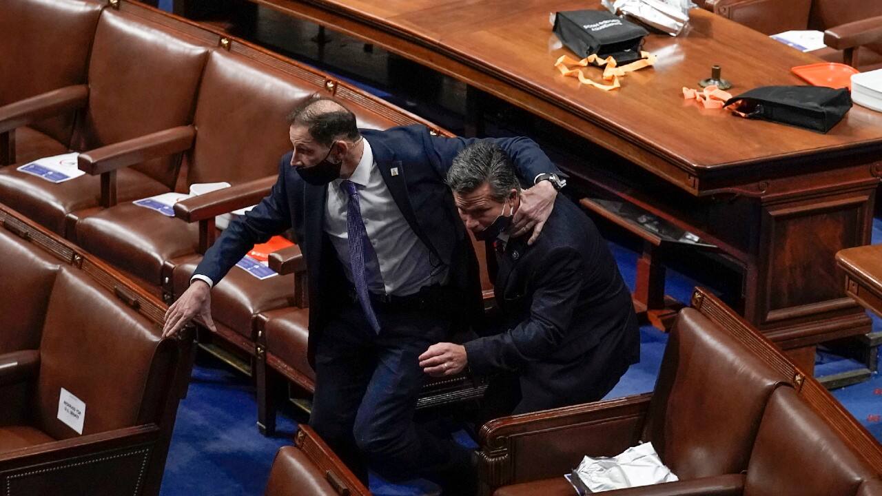 House of Representatives members leave the floor of the House chamber as protesters try to break into the chamber at the US Capitol in Washington DC. (Image: AP Photo/J. Scott Applewhite)