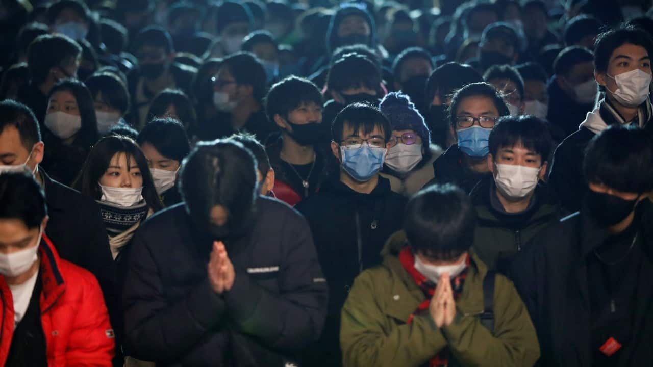 People wearing protective face masks gather as they offer prayers on the first day of the New Year at the Kanda Myojin shrine in Tokyo, Japan. (Image: Reuters/Issei Kato)