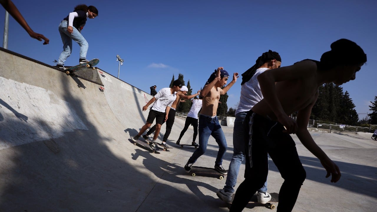 High above Jerusalem’s narrow medieval alleyways, teenage Palestinians sped across whitewashed roofs and soaked up the light and space denied to them during a six-week Israeli COVID-19 lockdown. (Image: Reuters)
